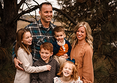 Doctor Vacek smiling outdoors with his family